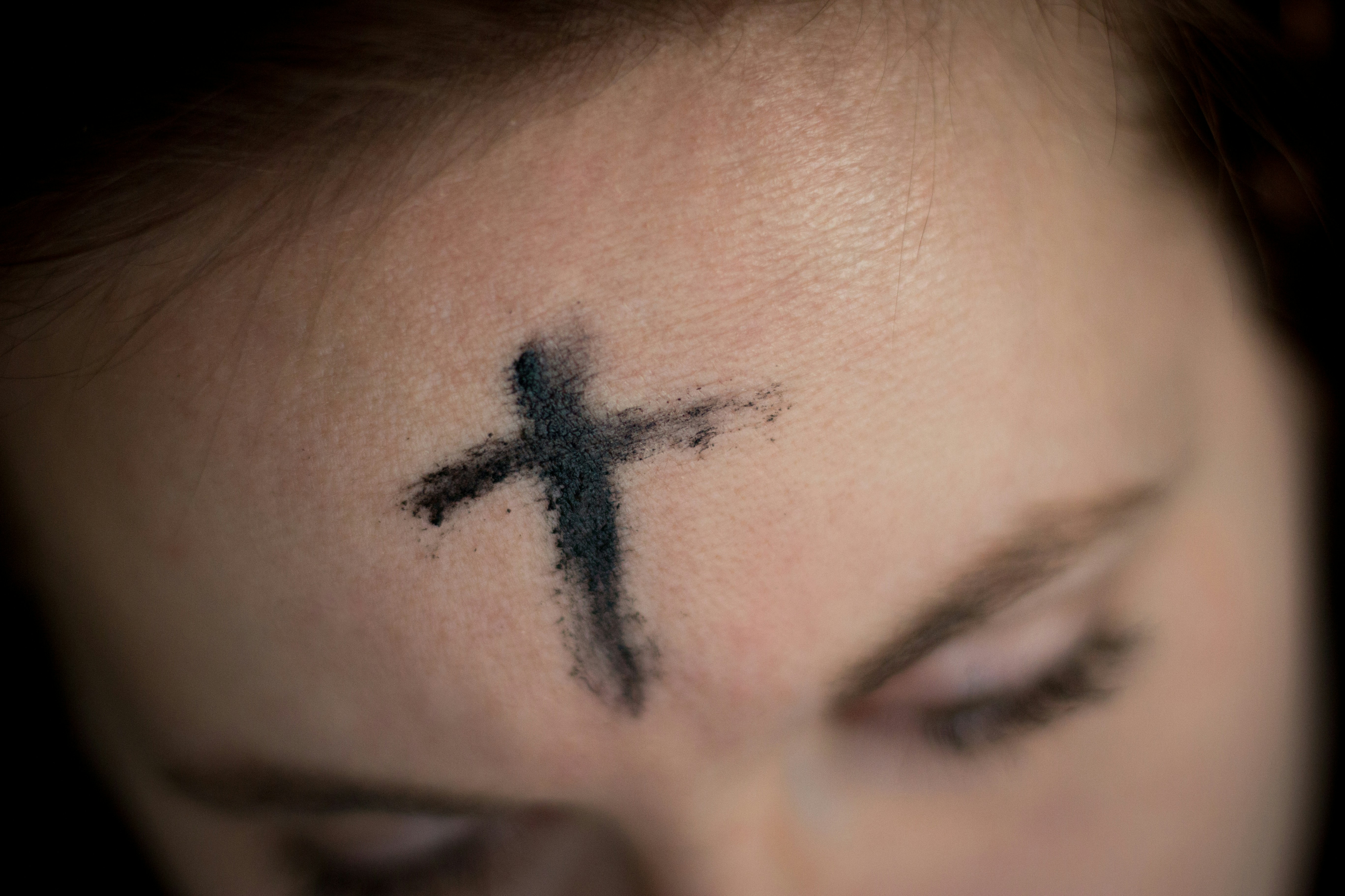 a face showing an ash cross during lent