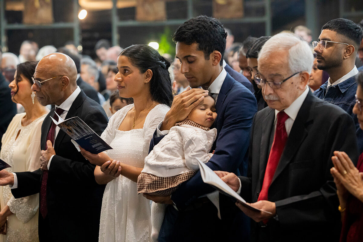 Catholic family participating in church service with prayer books
